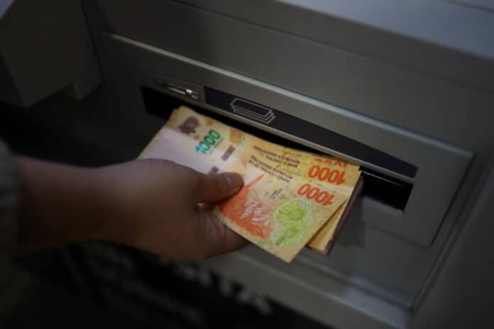Una mujer extrae dinero desde un cajero automático en Buenos Aires